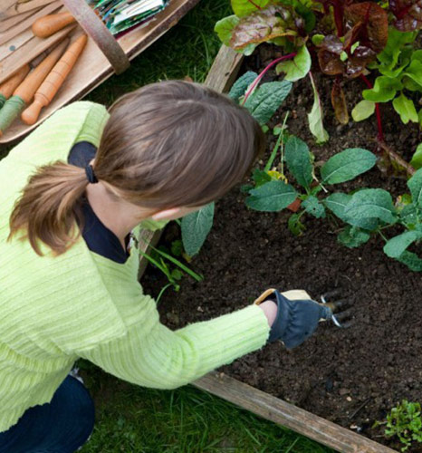 woman gardening with big yellow bag black garden soil